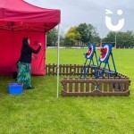 Axe Throwing Set up Hire at an outdoor Corporate Fun Day being enjoyed by a woman