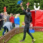 Axe Throwing Set up Hire at an outdoor Corporate event with a Fun Expert encouraging people over 