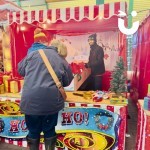 Penguin Skittles Stall set up at a festive market with a mother and sone enjoying playing