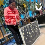 Christmas themed mega buzz wire being enjoyed by a woman in a Christmas jumper 