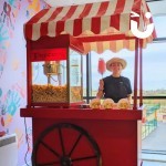 Candy Floss and Popcorn on the same cart at a school with a fun expert smiling