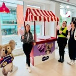 A Branded Candy Floss Cart for a promotional event with 3 women enjoying their fresh candy floss!