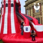 Inflatable Helter Skelter Slide at an outdoor Corporate fun day with laughing colleagues