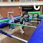 Human Table football outside on a hard ground with colleague celebrating their goal!