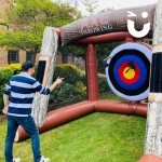 Inflatable Axe Throwing at an outdoor corporate event with a man taking aim!
