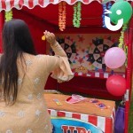 Prize Darts Stall Hire at a corporate fun day being enjoyed by a woman taking aim